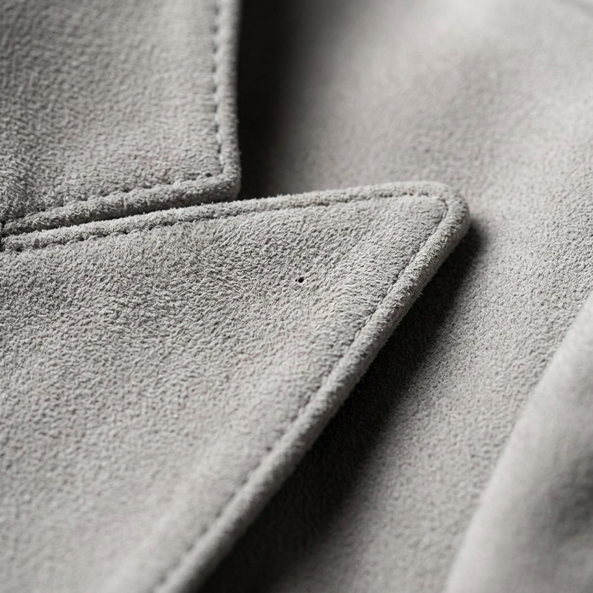 Macro du suède de porc gris et d'un bouton doré, blazer RADICE Maison Godefroi