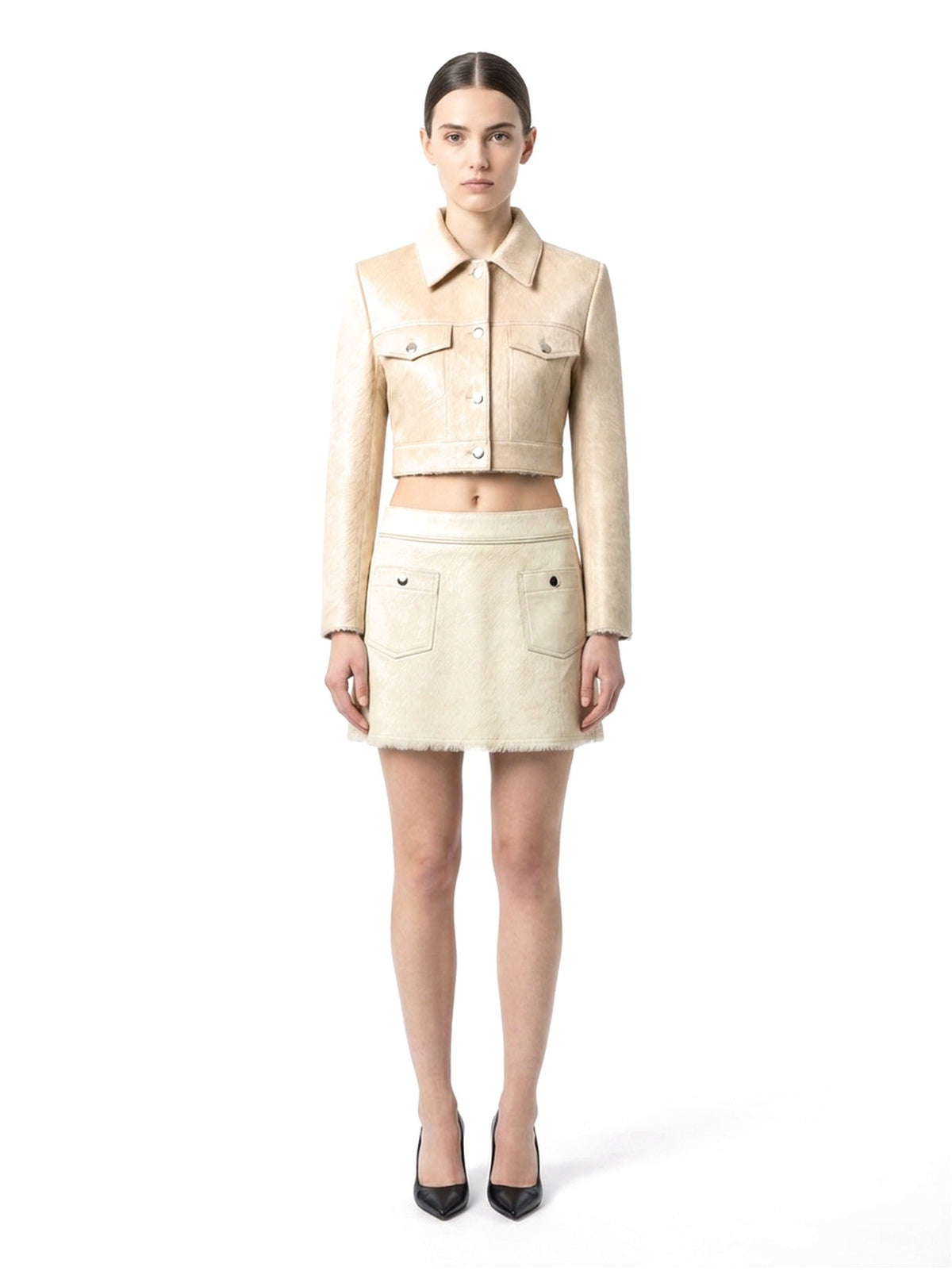 Jupe courte en poil de veau à ras crème, portée avec la veste assortie, vue de face.
