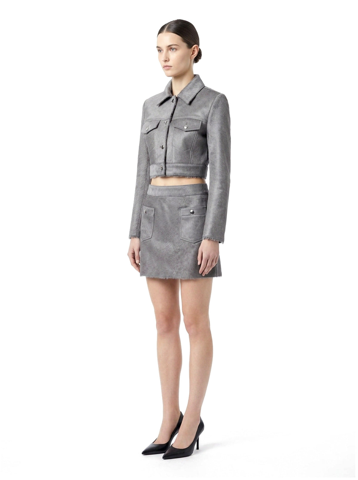 Veste courte en poil de veau à ras gris, portée avec la jupe assortie, vue trois-quarts.