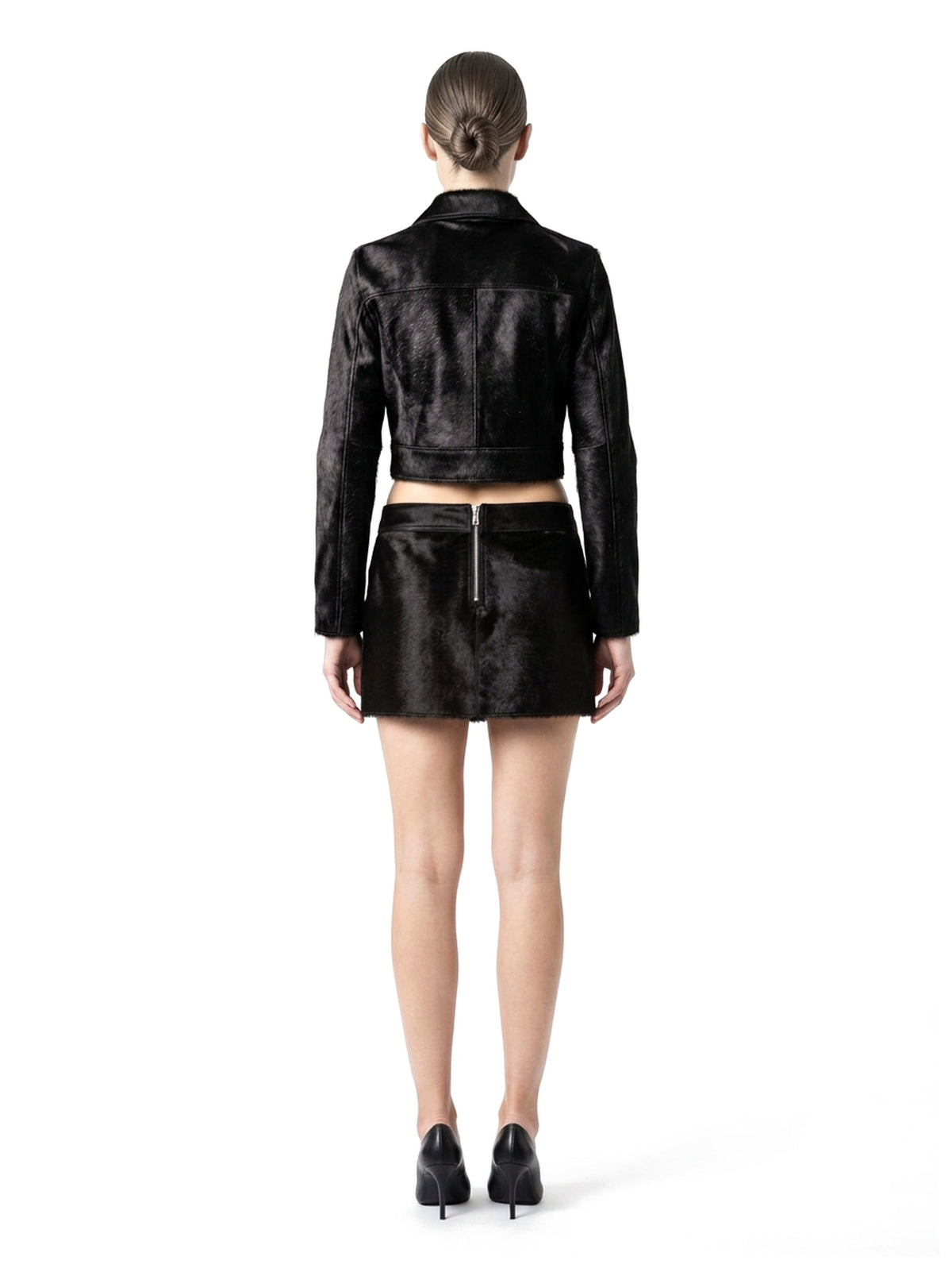 Ensemble veste courte et jupe courte en poil de veau à ras noir, porté par un mannequin, vue de dos.