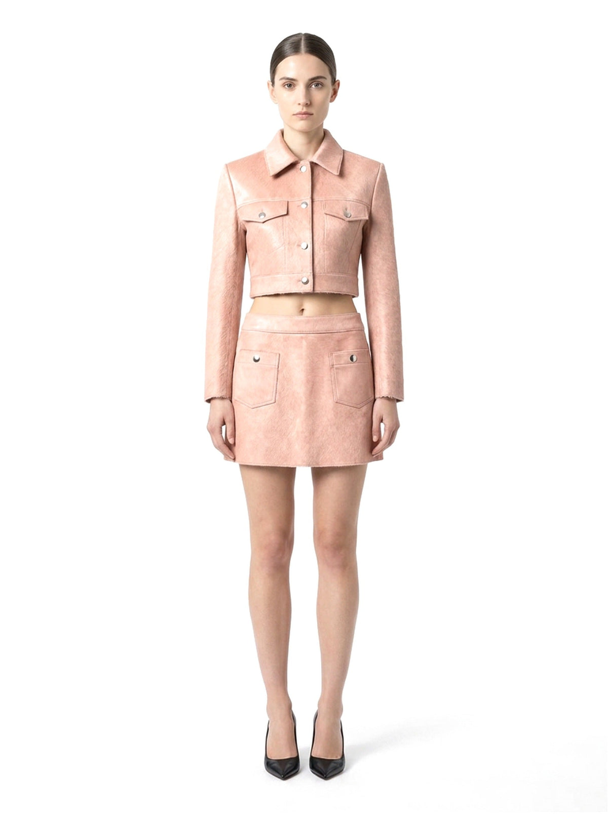 Jupe courte en poil de veau à ras rose, portée avec la veste assortie, vue de face.