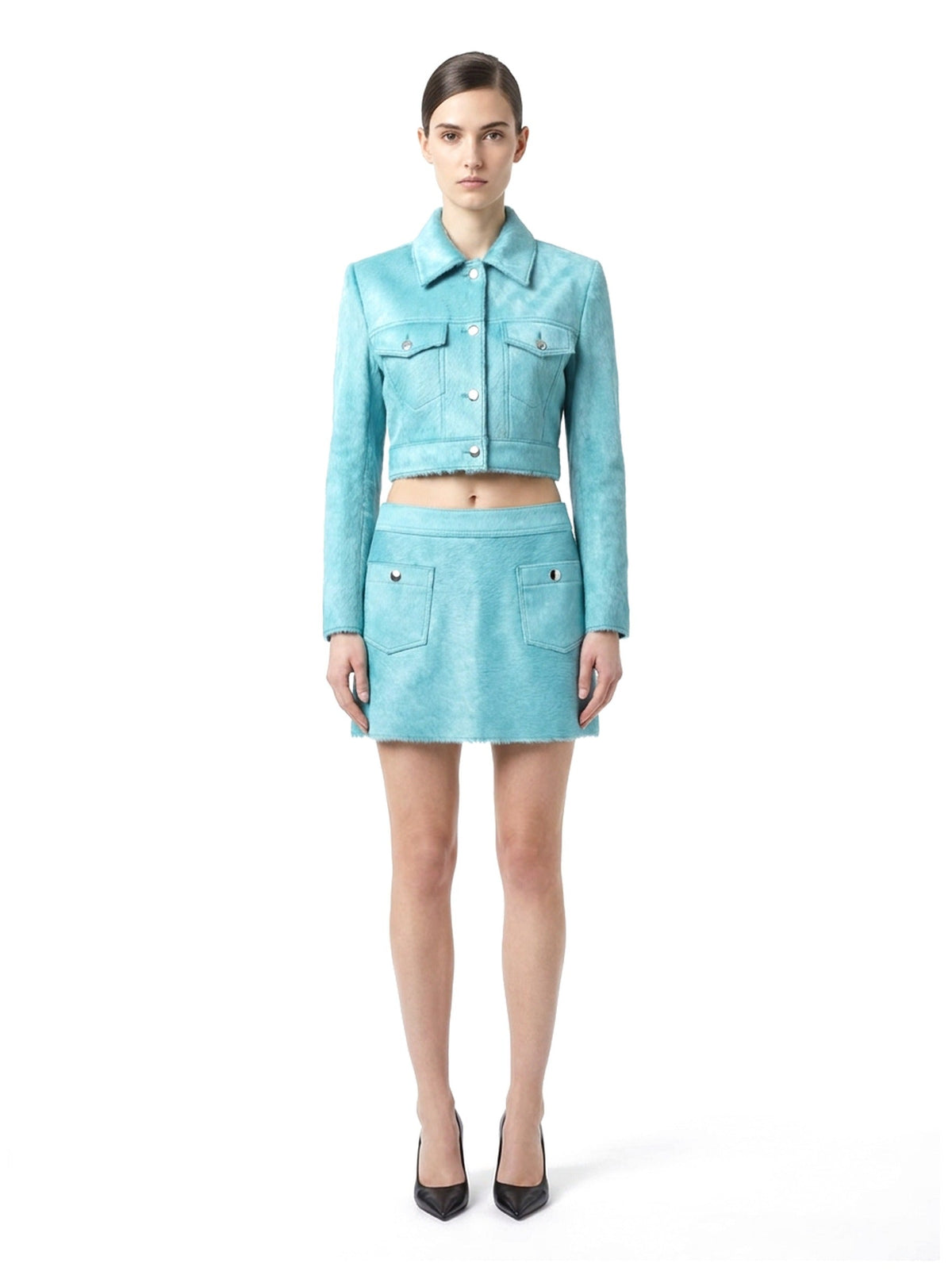 Jupe courte en poil de veau à ras turquoise, portée avec la veste assortie, vue de face.