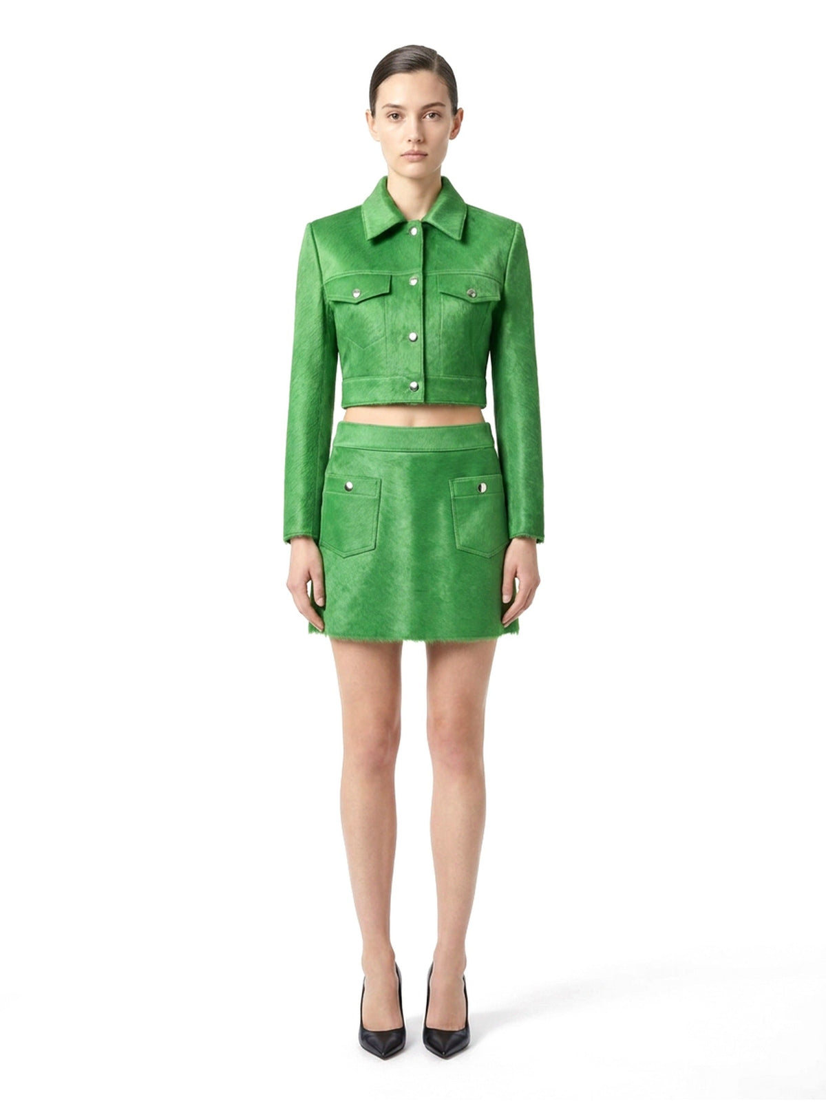 Jupe courte en poil de veau à ras vert, portée avec la veste assortie, vue de face.