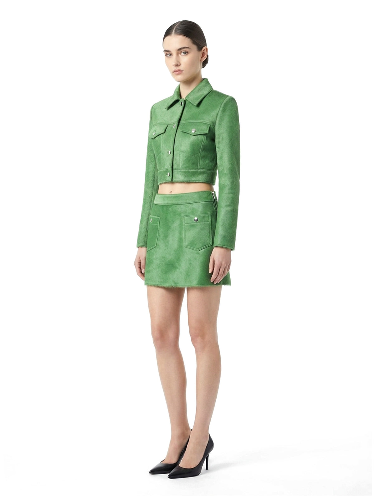 Ensemble veste courte et jupe courte en poil de veau à ras vert, porté par un mannequin, vue trois-quarts.
