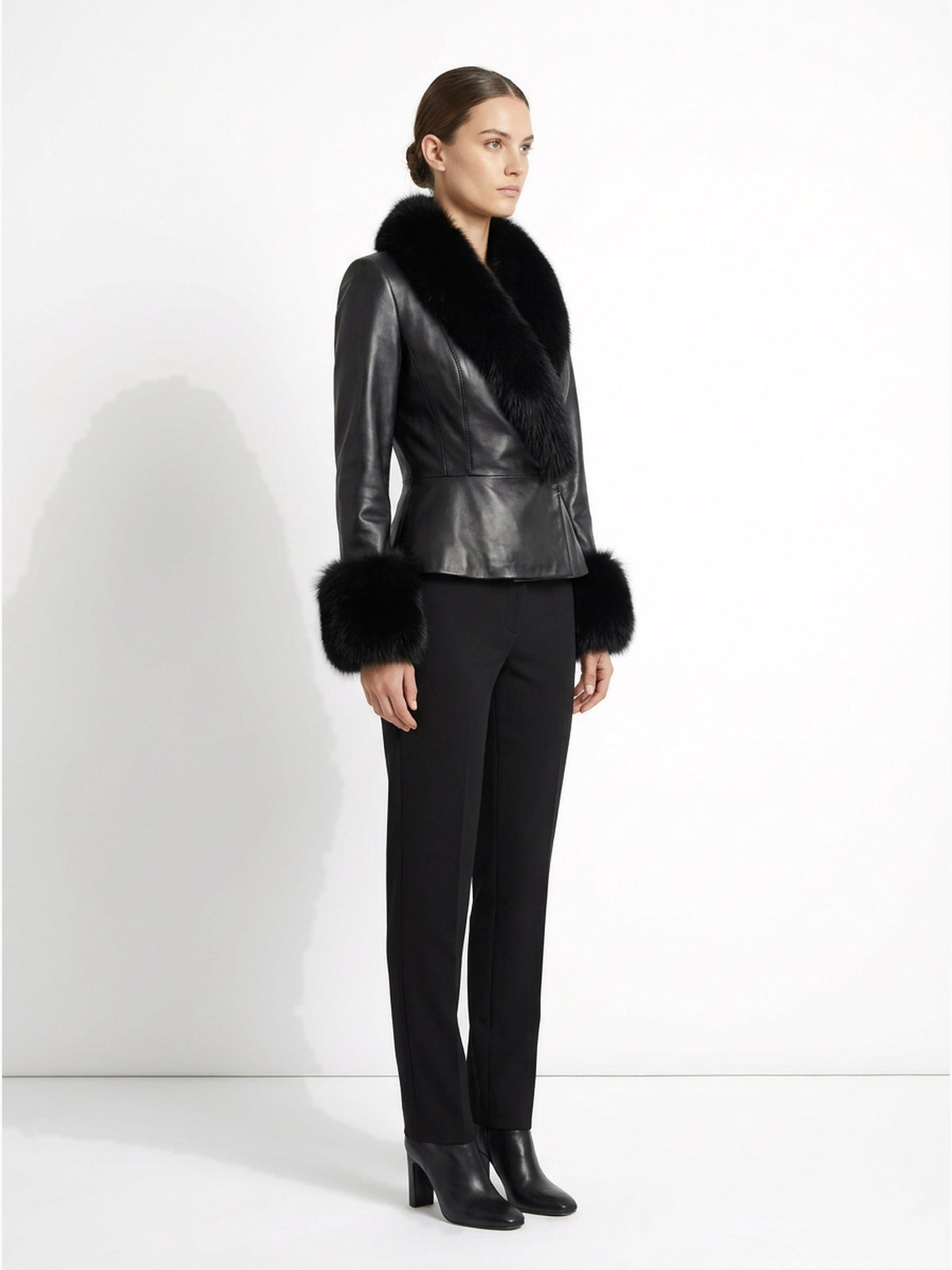 Veste en cuir noir à col de fourrure portée de trois-quarts, collection RADICE