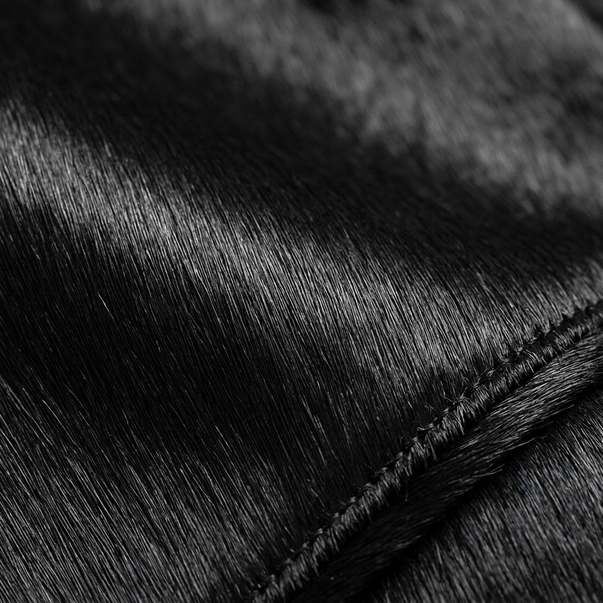 Cuir façon poulain noir en macro, poil couché dans un seul sens